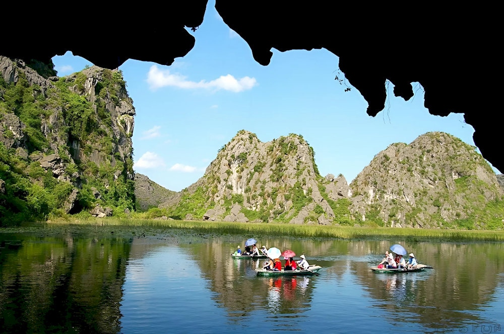 Towering limestone mountains rise on both sides, their reflections mirrored in the tranquil water